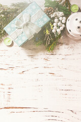 Winter concept. Christmas or New Year layout with fir tree branch and Christmas present on a snow wooden table. Flat lay, copy space.