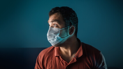 A tanned man in a medical mask on a blue background. Infectious viral disease. Personal hygiene products.