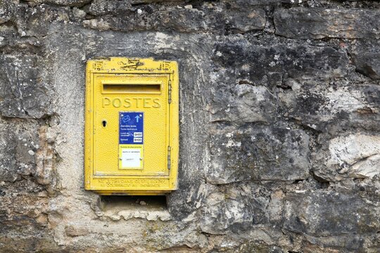 Old yellow french letterbox on a wall