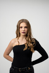 Fototapeta premium Beautiful young woman portrait in a black t-shirt. Studio shot, isolated on gray background.