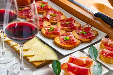 Aperitivos españoles. Aperitivos de jamón ibérico con una copa de vino, tomates maduros y queso...
