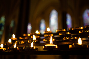candles in church against stained glass windows