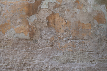 Alte verputzte Steinmauer, an der der Putz abbröckelt (Mauer / Textur)
