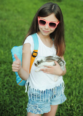 The girl hugs a little cute rabbit. Rabbit symbol of Easter. 