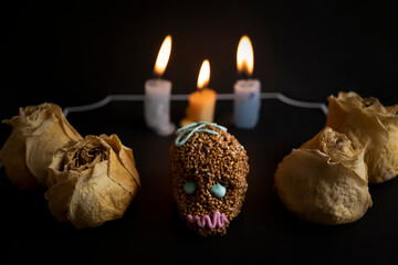 calaverita de chocolate mexicana con rosas secas y velas de fondo