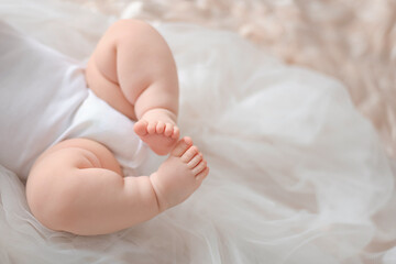 a small child is lying on the bed, tiny cute legs close-up, shallow focus