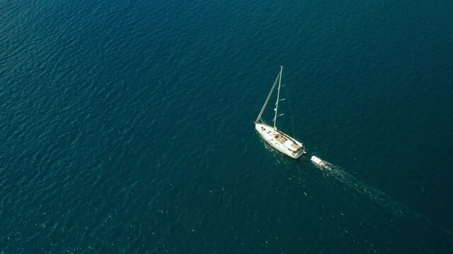 White sailboat or yacht sails on the sea with blue water. Aerial view of Adriatic sea and vessel
