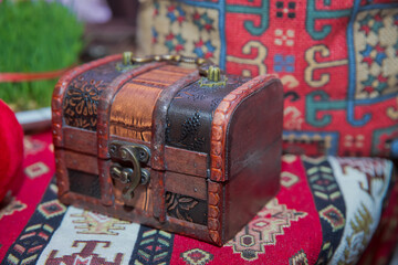 A small wooden box on the carpet . A small wooden box .