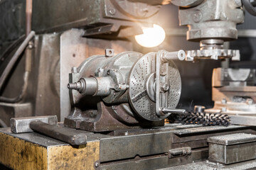 Old milling machine with working lighting close-up equipment in the shop of an industrial enterprise
