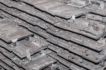 Iron parts of the workpiece for laying railway tracks metal structures in a heap at an industrial plant