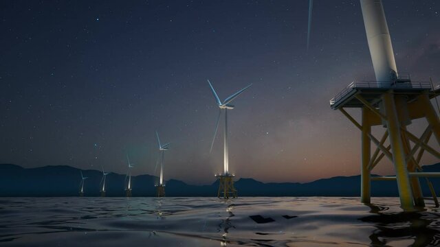 Offshore wind turbines spin around in the starry night marine background.