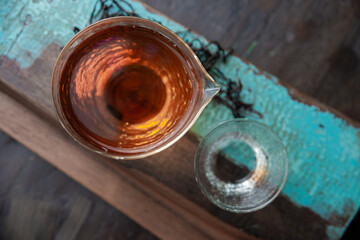 Beautiful indoor overview scene with tea pot and tea glass on the top of old wooden table
