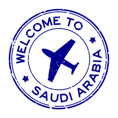 Grunge blue welcome to Saudi Arabia word with airplane icon round rubber seal stamp on white background