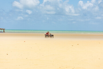 Fototapeta na wymiar Passeio de quadriciclo na areia a beira mar