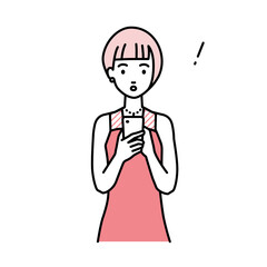 立ってスマートフォンを操作して何かに気づいて驚いたドレスの女性