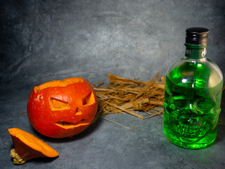 Silhouette of a pumpkin and a bottle of absinthe  in the dark.