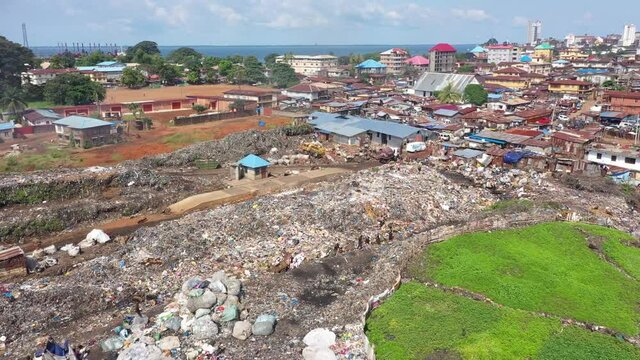 Aerial scavengers city garbage dump Freetown Sierra Leone. West Africa suffers extreme poverty hunger. Crowded homes and businesses. Tropical climate. Bad Transportation infrastructure.