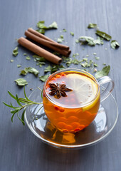 Vitamin tea with lemon, sea buckthorn berries in a transparent cup