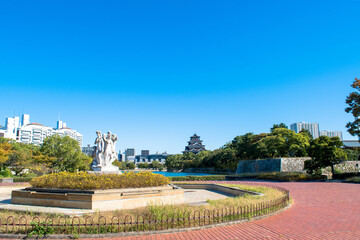 広島城天守閣と花の精像