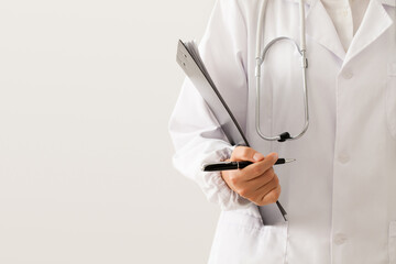 close up of doctor standing with pen and medical records in hand on white background.
