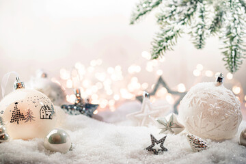 Fototapeta na wymiar Christmas white decorations on snow with fir tree branches and christmas lights. Winter Decoration Background