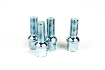 Large car wheel bolts made of silver metal. Isolated over white background. close-up