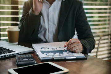 Fototapeta premium Male writes information businessman working on laptop computer writing business plan while sitting in office.