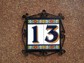 House number 13: dark blue numbers with orange shading on glazed ceramics plaques 