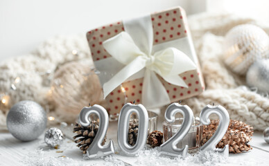 Fototapeta na wymiar Christmas background with candles in the form of numbers 2022 and a gift box.