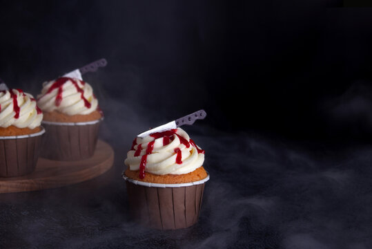 Close up photo of scary, blody Halloween cupcakes. Black background. Food photo
