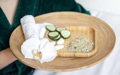 Obraz na płótnie Canvas Spa composition with wooden plate with cucumber slices and sea salt.