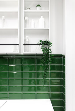 Bathroom Interior With Green Tiles And White Cabinets On The Wall.