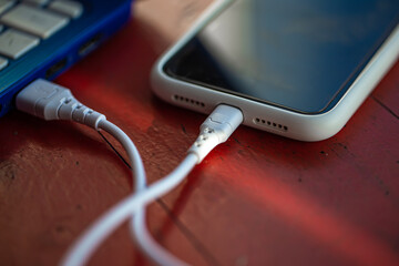 The smartphone is connected to the laptop via USB cable.