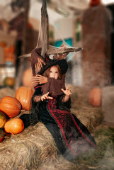 a little girl on Halloween depicts fear or horror. Sweets or life. A girl in a witch costume bites the hand of a monster