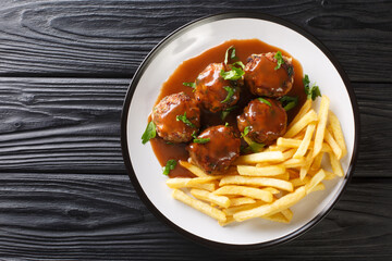 Boulets liegeois Liege Meatballs in apple sauce and French fries closeup in the plate on the table. Horizontal top view from above