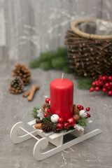 Christmas composition with candle in small sleigh.