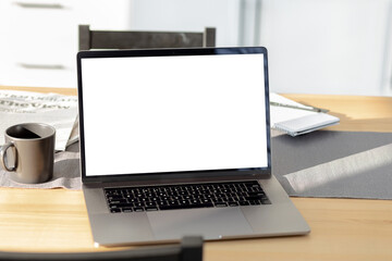 Laptop computer with blank screen in on table in home office