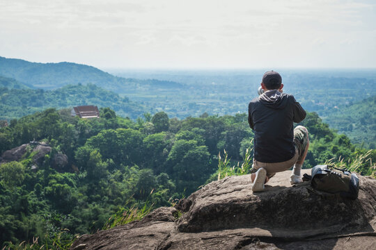 Travel photographer taking pictures on top of mountain. Concept, adventure, outdoor and lifestyle.