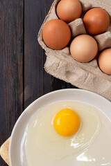 Chicken brown eggs closeup top view on wooden table background. Organic chicken eggs in a egg carton.