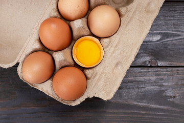 Chicken brown eggs closeup top view on wooden table background. Organic chicken eggs in a egg carton.