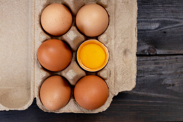 Chicken brown eggs closeup top view on wooden table background. Organic chicken eggs in a egg carton.