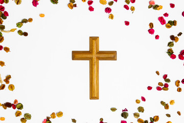 A wooden cross with flowers on white background.