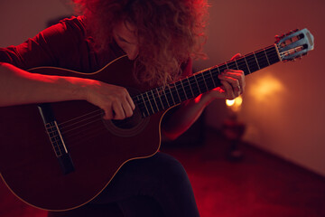 Obraz na płótnie Canvas Woman playing acoustic guitar in a retro vintage room.