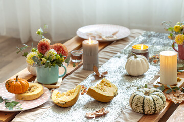 Festive table setting with pumpkins and chrysanthemum flowers.