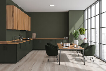 Green kitchen interior with table and chairs on parquet floor near window