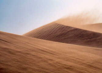 Sandy storm and extreme dry wind in Namib desert, Africa. Windy weather over lifeless sand dunes,...
