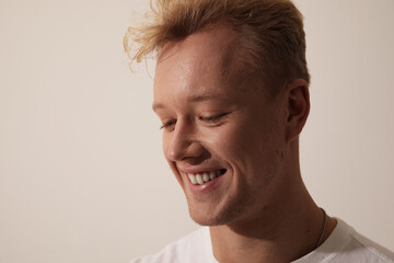 Fototapeta premium Close-up of a handsome young man smiling against white background.