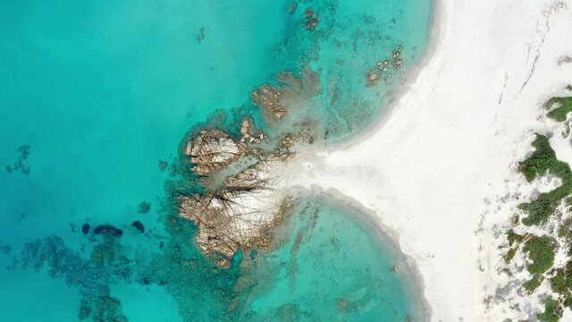 View from above, stunning aerial view of a white sand beach bathed by a turquoise water. Rena Majore, Sardinia, Italy.