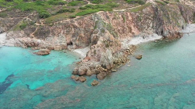 View from above, stunning aerial view of a rocky coastline bathed by a turquoise water. Rena Majore, Sardinia, Italy.