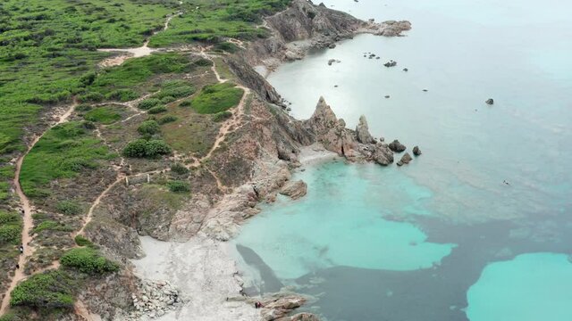 View from above, stunning aerial view of a rocky coastline bathed by a turquoise water. Rena Majore, Sardinia, Italy.